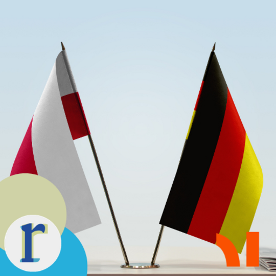 Small Polish and German desk flags standing side by side, symbolising bilateral relations between Poland and Germany.