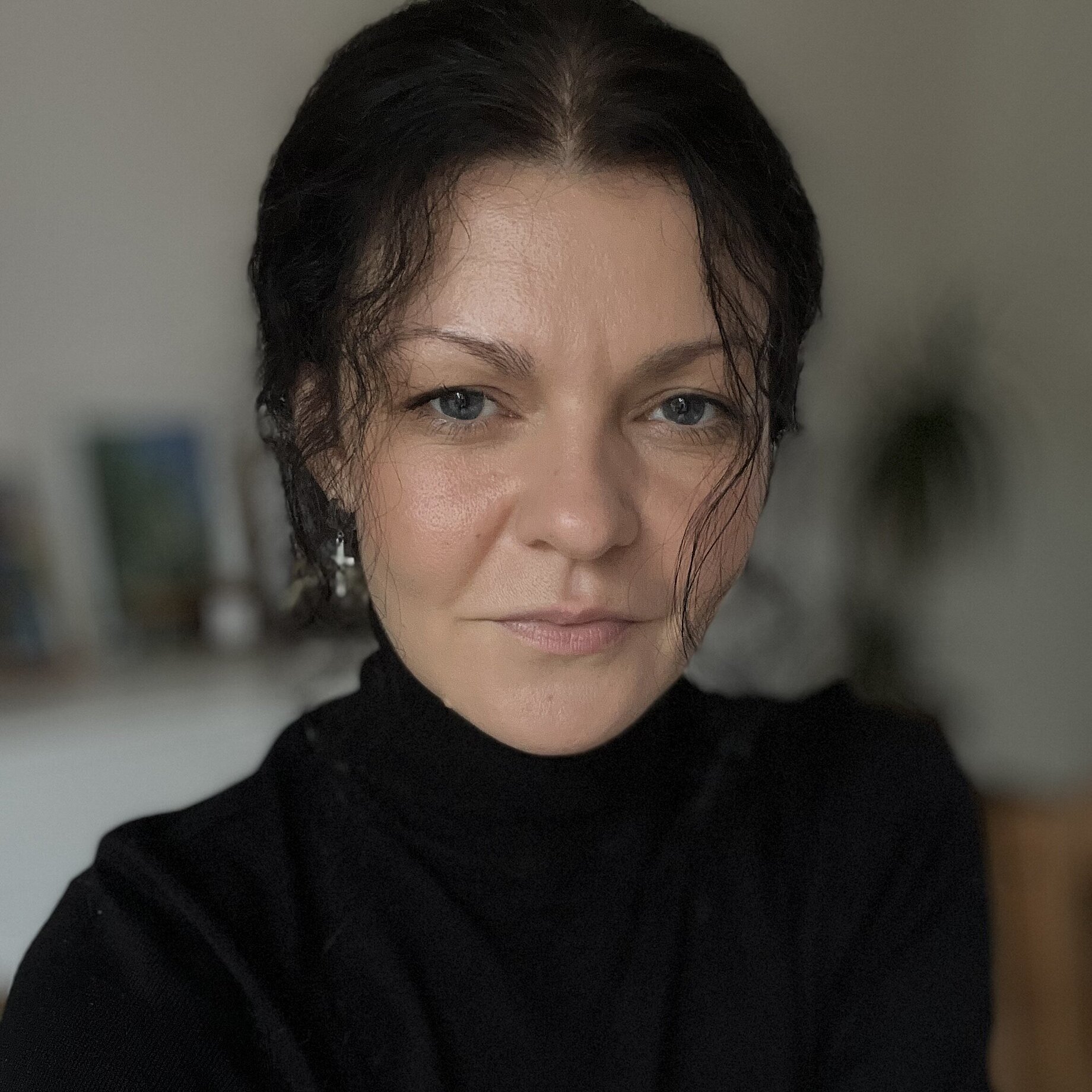 A woman with dark hair in an updo wearing a dark tricot.