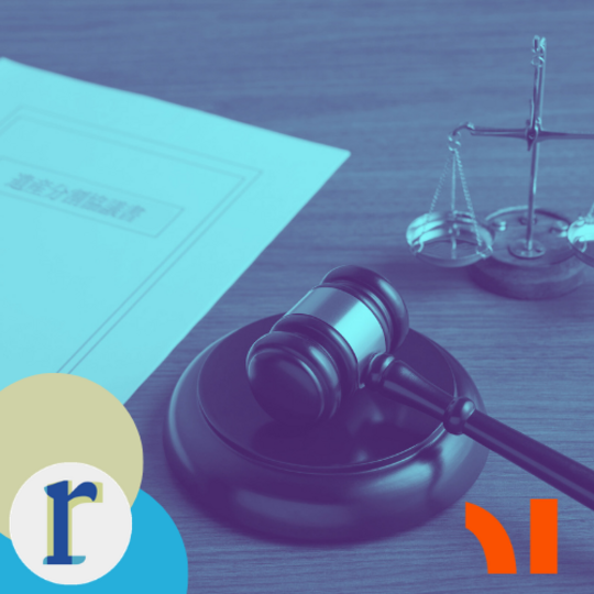 A gavel and a set of scales on a desk beside a document with text, in a blue duotone tint.