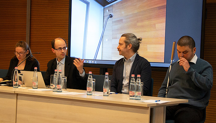 Four panelists seated at a table during event.